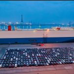 a large ship with cars parked in a port